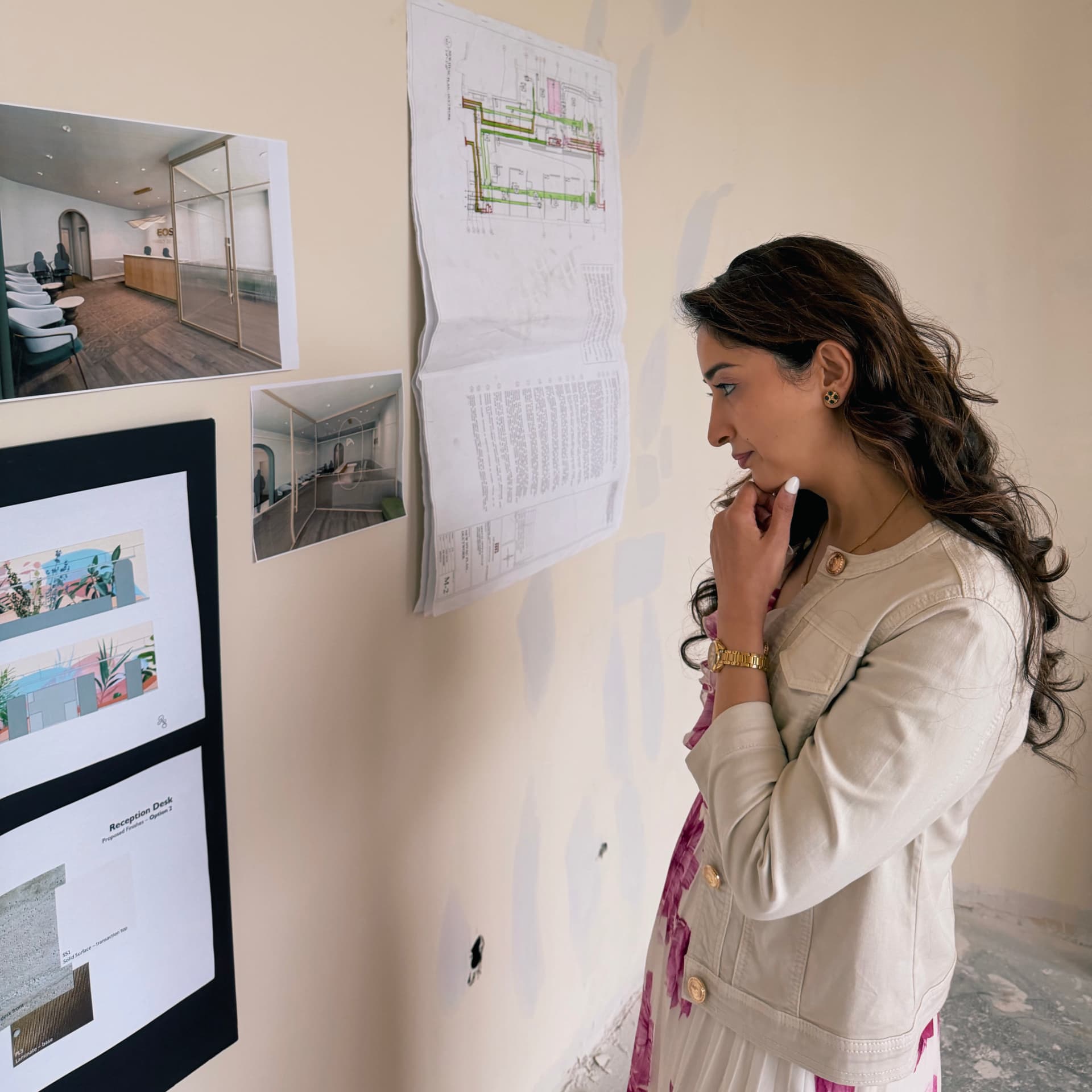 Dr. Isha Moza reviewing plans and interior renderings inside the unfinished EOS Family Dental space.